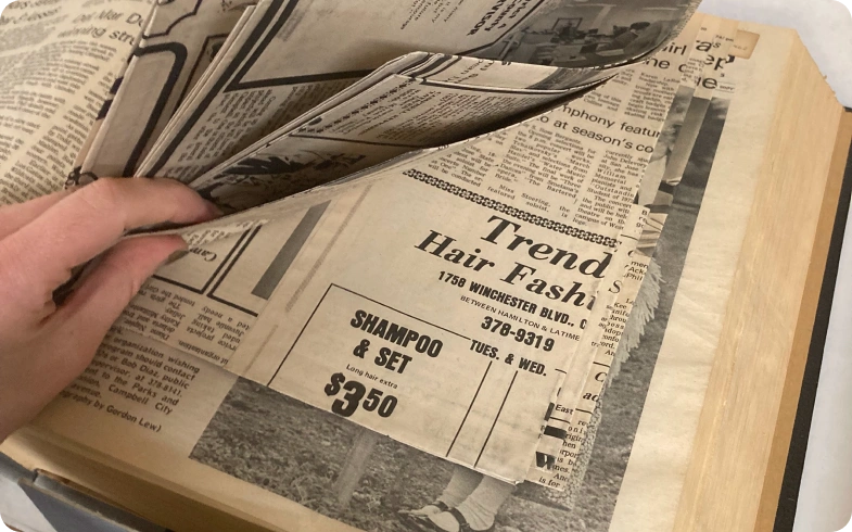 Flipping through fragile pages of the Campbell Press during newspaper digitization process